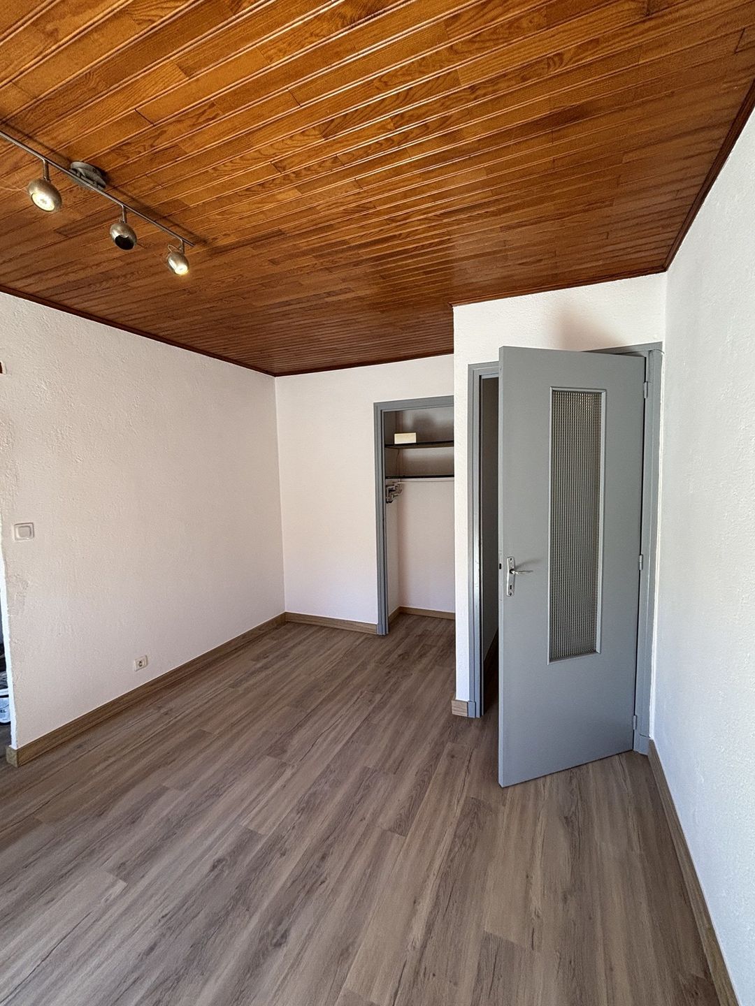 Après travaux à Saint-Cyprien : portes et encadrements repeints en gris, murs blancs, plafond lambris conservé