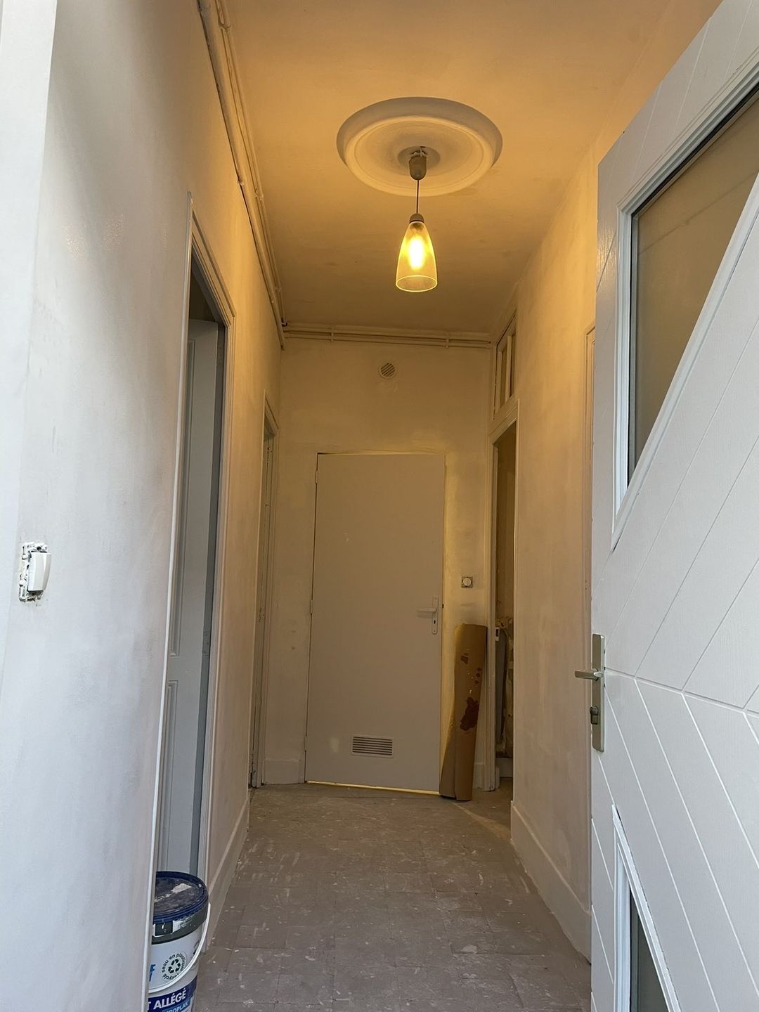 Avant travaux à Perpignan : couloir aux murs ratissés, sol ancien, avant mise en peinture