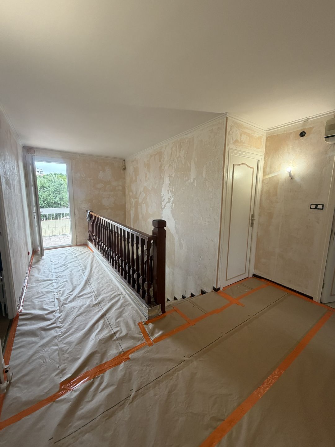 Avant travaux à Perpignan (Las Cobas) : palier aux murs détapissés, restes de papier peint et enduits, sols protégés