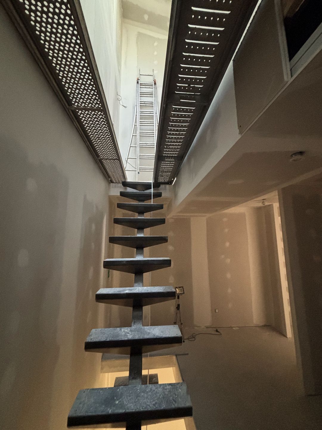 Avant travaux à Toulouges : logement en plaques de plâtre brutes avec bandes apparentes, escalier suspendu