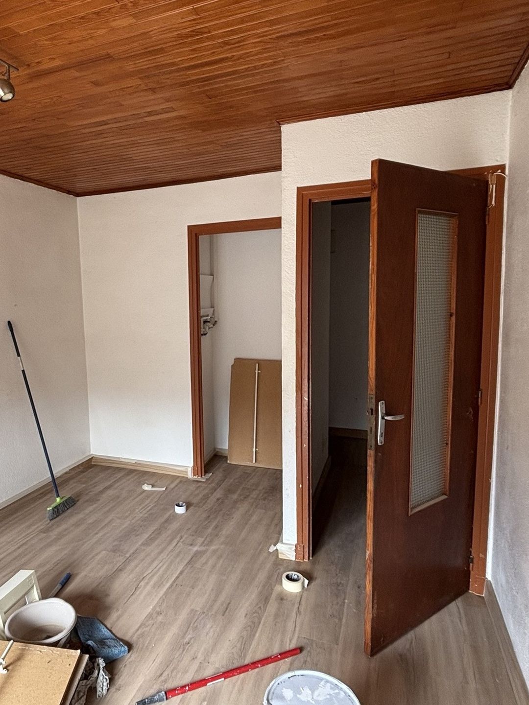 Avant travaux à Saint-Cyprien : séjour sous plafond lambris, portes et encadrements en bois foncé