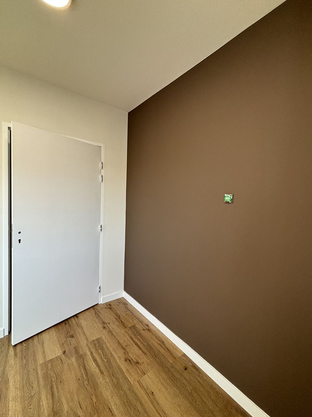 Bureau à Saint-Estève : mur brun, porte et plinthes blanches, coupe nette entre mur et plafond