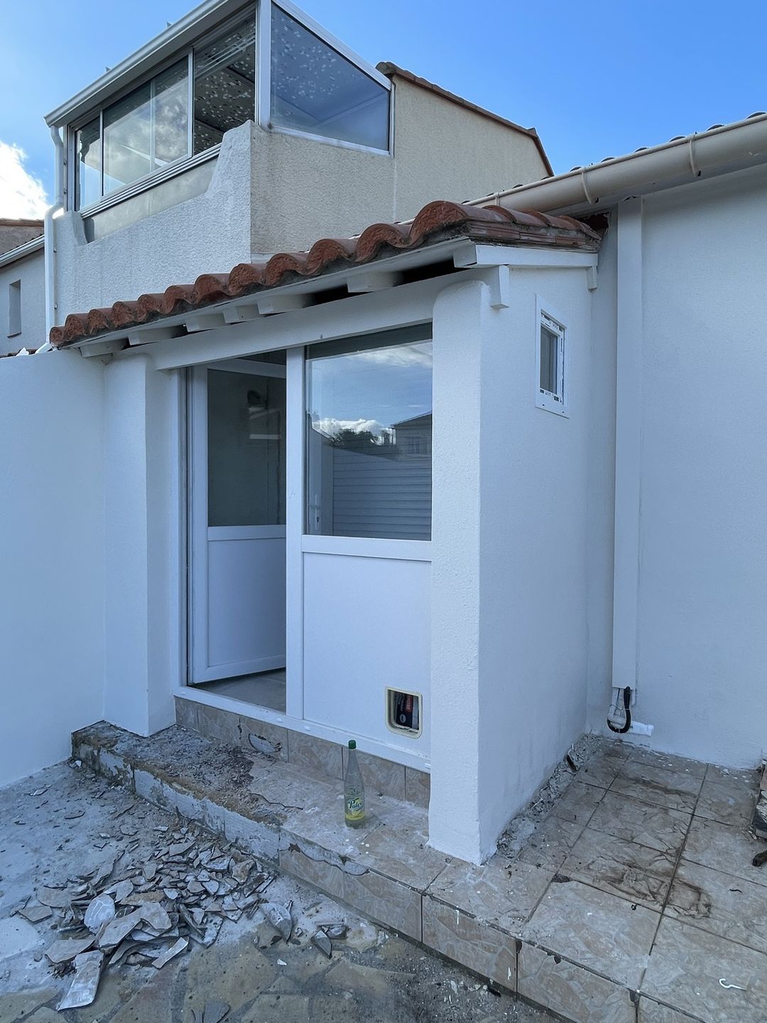 Entrée de maison à Rivesaltes : façade et murets enduits puis peints en blanc, auvent en tuiles
