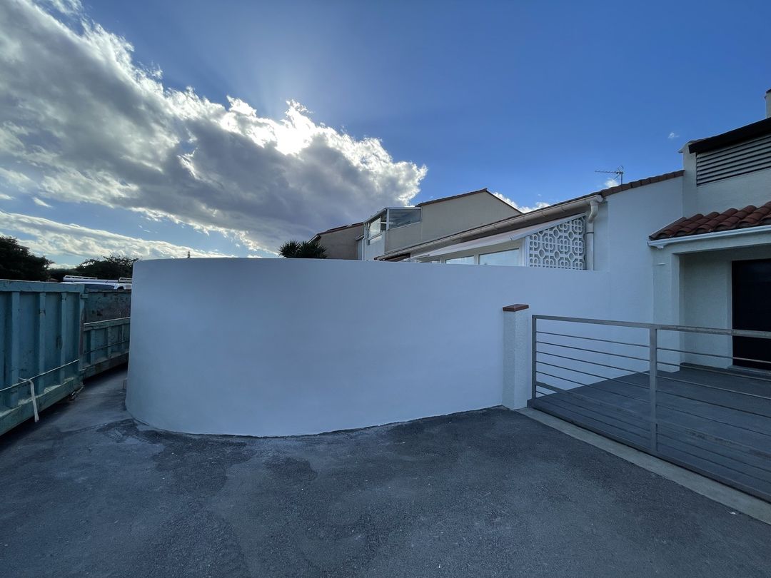 Muret arrondi entièrement enduit puis peint en blanc par Duflot Peinture à Rivesaltes, devant la maison